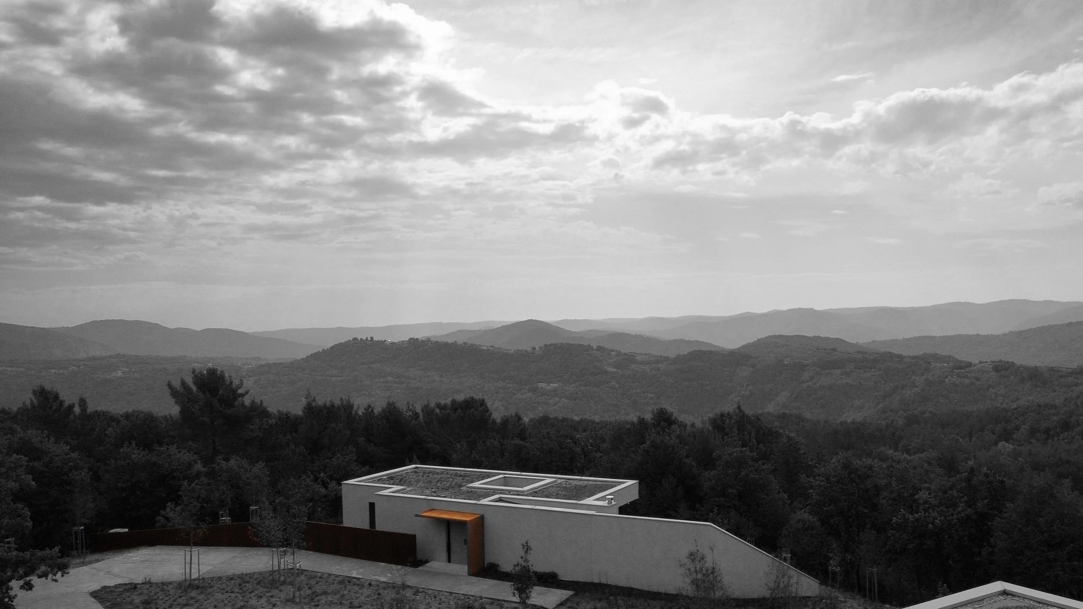 Contemporary villa with green roof and corten steel canopy — hillside aerial view Slovenia