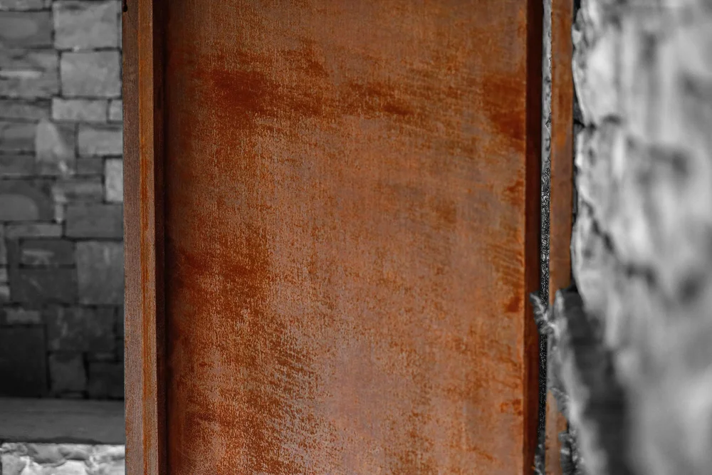 Corten steel door panel stone wall detail Croatia